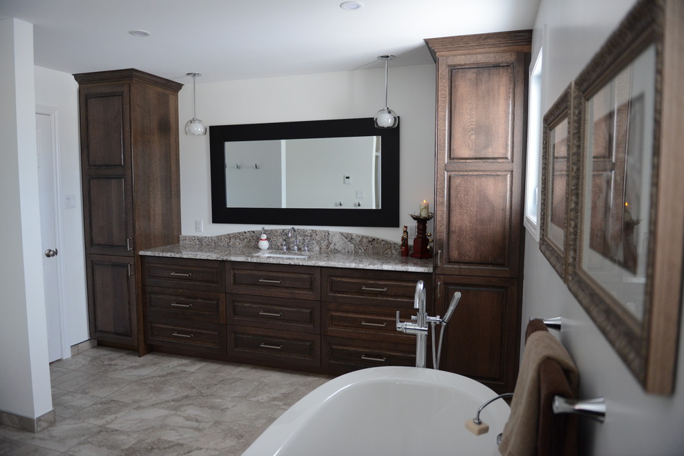 Inspiration for a large transitional master bathroom in Vancouver with raised-panel cabinets, dark wood cabinets, a freestanding tub, an alcove shower, a one-piece toilet, white walls, porcelain floors, an undermount sink, granite benchtops, multi-coloured floor, a hinged shower door and multi-coloured benchtops.