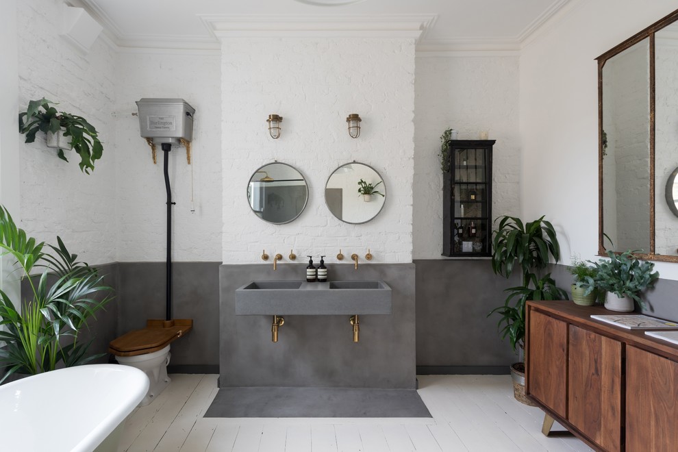 Design ideas for a large contemporary master bathroom in London with flat-panel cabinets, medium wood cabinets, a freestanding tub, white walls, painted wood floors, a wall-mount sink, concrete benchtops, white floor and grey benchtops.