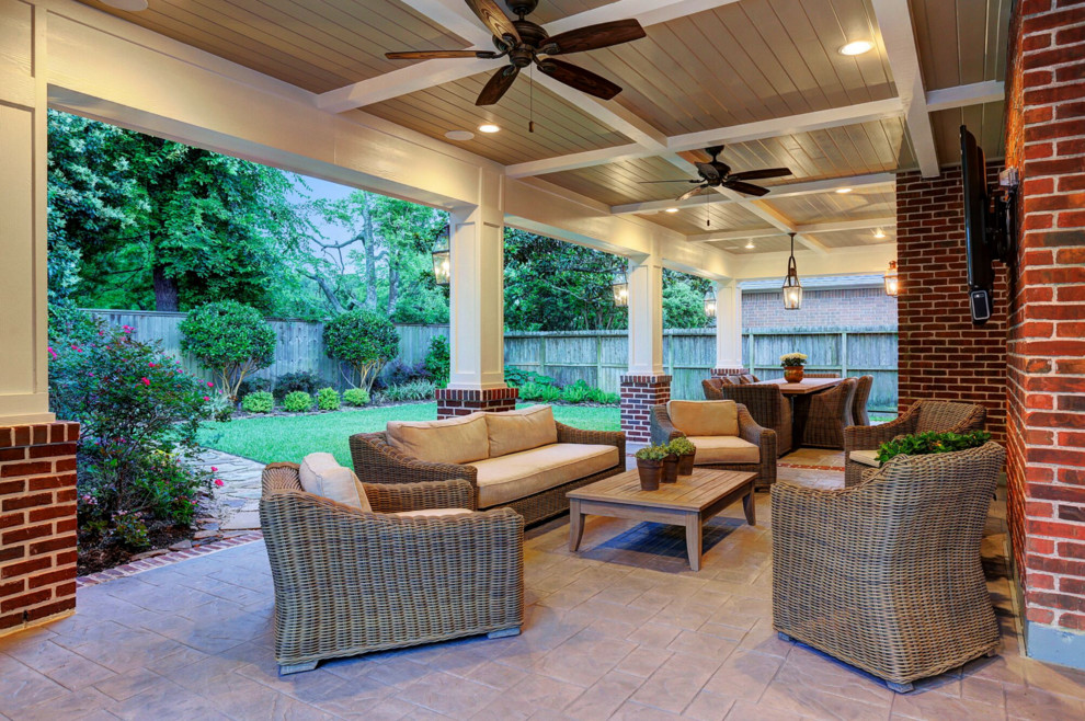 Design ideas for a mid-sized traditional backyard patio in Houston with stamped concrete and a roof extension.