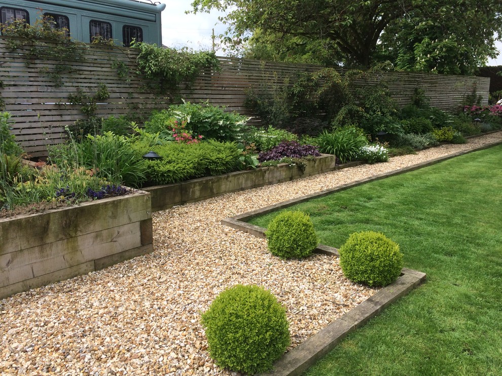 Photo of an expansive contemporary backyard full sun formal garden for summer in Cheshire with a retaining wall and gravel.