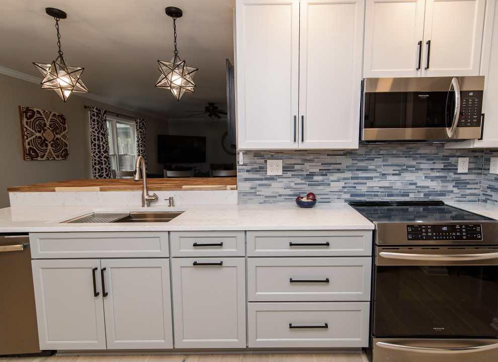 Inspiration for a mid-sized transitional u-shaped enclosed kitchen remodel in Baltimore with an undermount sink, shaker cabinets, white cabinets, quartz countertops, blue backsplash, subway tile backsplash, stainless steel appliances, a peninsula and white countertops