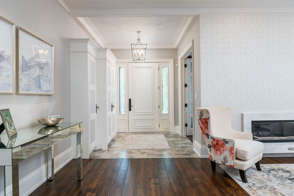 Photo of a mid-sized transitional front door in Toronto with white walls, a single front door, a white front door, multi-coloured floor and dark hardwood floors.