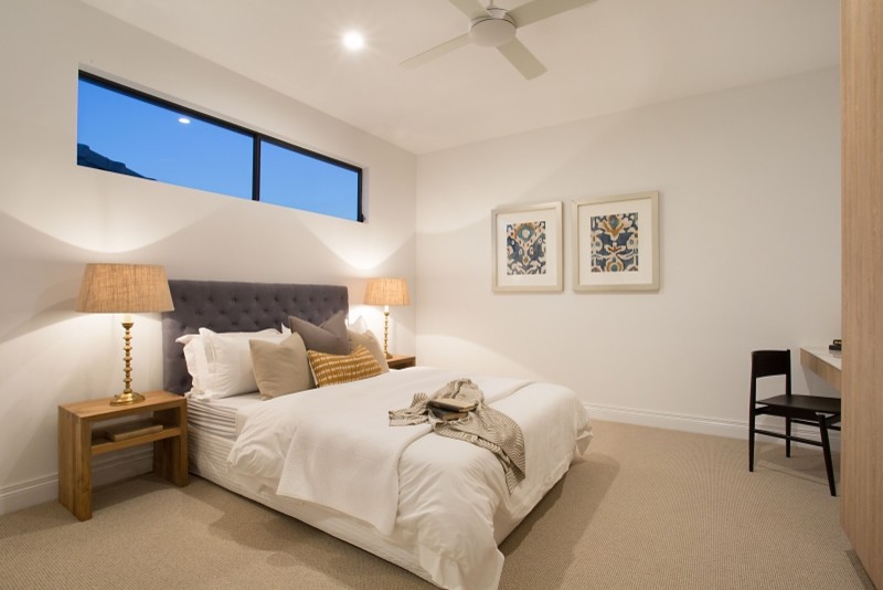 Photo of a mid-sized modern guest bedroom in Gold Coast - Tweed with white walls, carpet, a corner fireplace and beige floor.