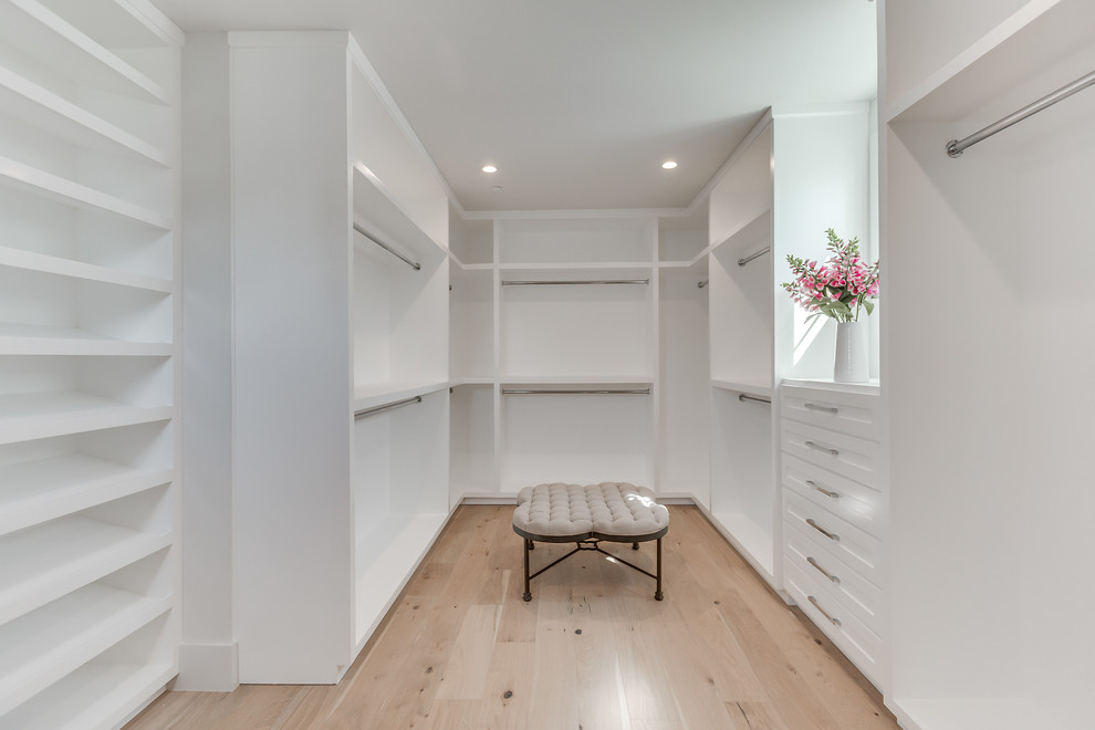 Large contemporary gender-neutral walk-in wardrobe in Los Angeles with open cabinets, white cabinets, light hardwood floors and brown floor.