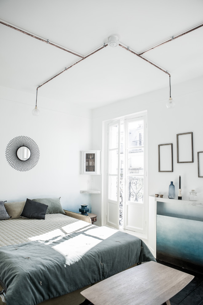 This is an example of a mid-sized scandinavian master bedroom in Paris with white walls, slate floors and no fireplace.