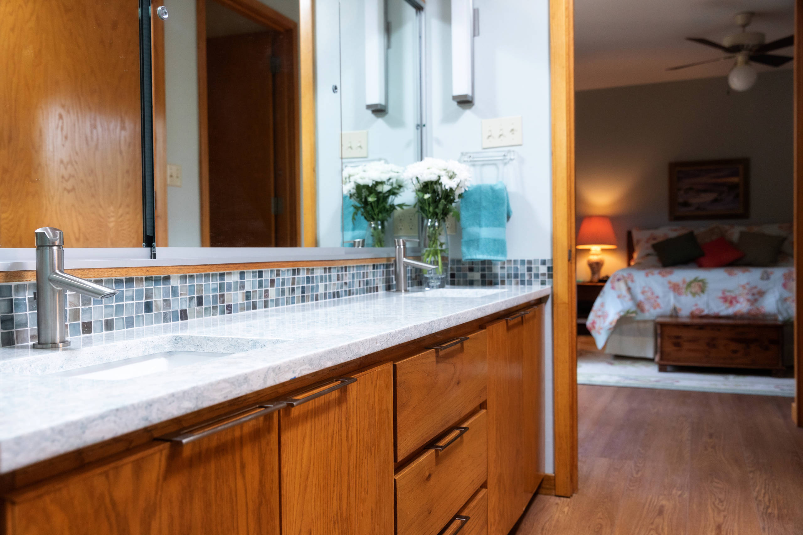 Example of a mid-sized master multicolored tile and mosaic tile brown floor bathroom design with flat-panel cabinets, medium tone wood cabinets, blue walls, an undermount sink, granite countertops and