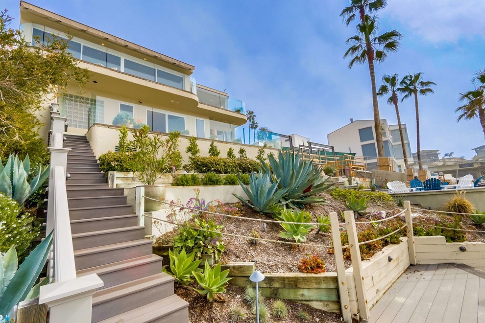 Photo of a mid-sized beach style two-storey stucco beige house exterior in Orange County.