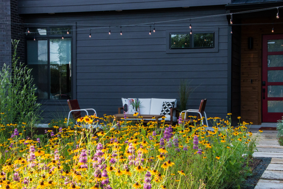 Идея дизайна: солнечный, весенний засухоустойчивый сад среднего размера на переднем дворе в стиле модернизм с клумбами, хорошей освещенностью, покрытием из гравия и с деревянным забором