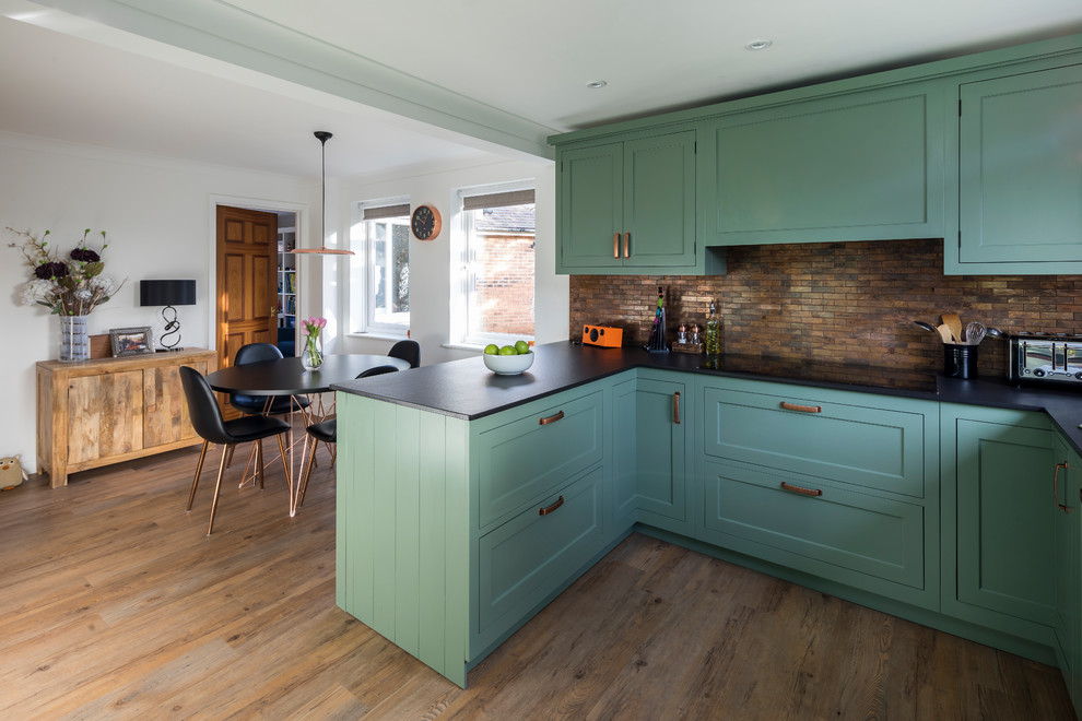 Inspiration for a mid-sized traditional u-shaped eat-in kitchen in Kent with a farmhouse sink, shaker cabinets, green cabinets, quartz benchtops, metal splashback, linoleum floors, a peninsula and green floor.