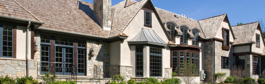 Design ideas for an expansive traditional two-storey grey exterior in Chicago with stone veneer and a gable roof.