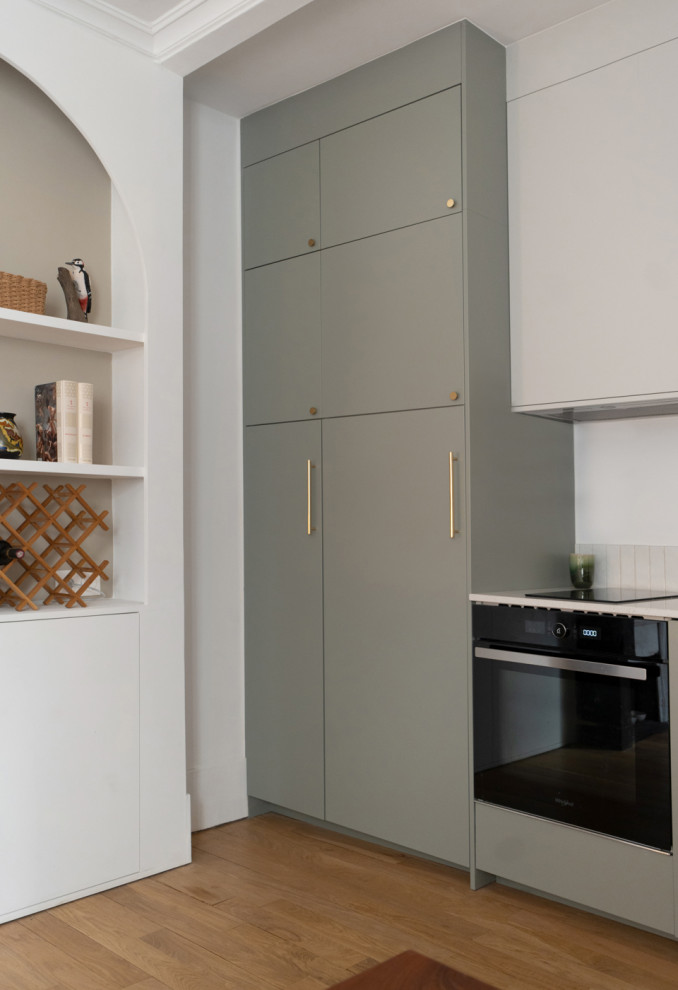 Exempel på ett minimalistiskt vit vitt kök med öppen planlösning, med en undermonterad diskho, släta luckor, grönt stänkskydd och bänkskiva i kvartsit
