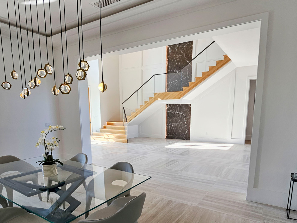 This is an example of an expansive contemporary wood floating staircase in DC Metro with wood risers, mixed railing and decorative wall panelling.