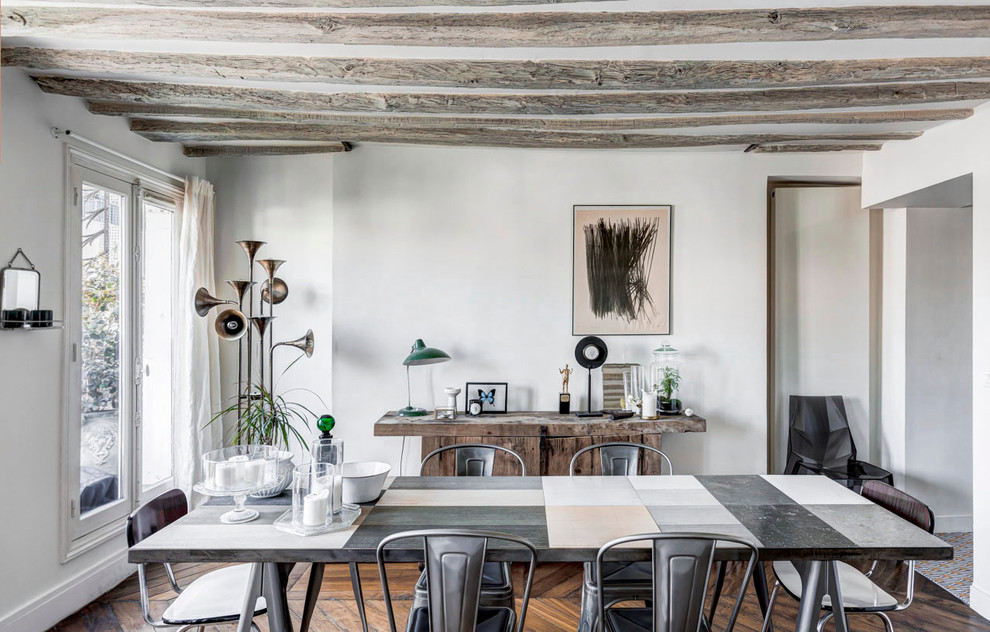 Inspiration for a country dining room in Paris with white walls and dark hardwood floors.