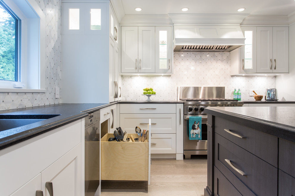 Inspiration for a large transitional l-shaped medium tone wood floor and beige floor eat-in kitchen remodel in Vancouver with an undermount sink, shaker cabinets, white cabinets, granite countertops, gray backsplash, marble backsplash, stainless steel appliances, an island and black countertops