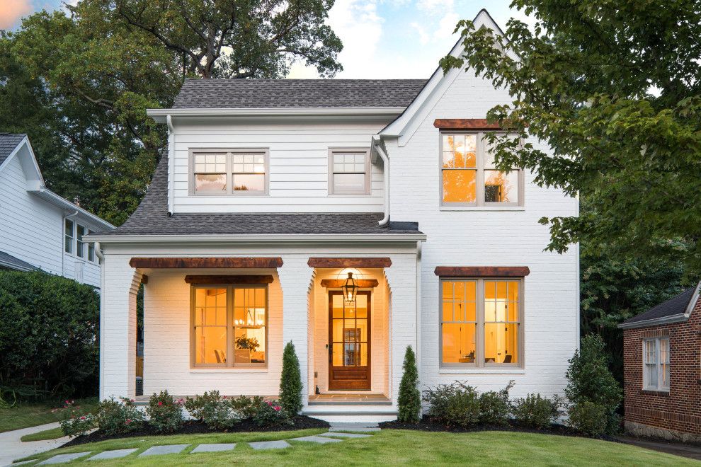 This is an example of a mid-sized transitional two-storey brick white house exterior in Atlanta with a gable roof and a shingle roof.