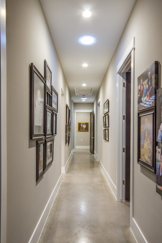 Photo of a small modern hallway in Austin with concrete floors and grey walls.