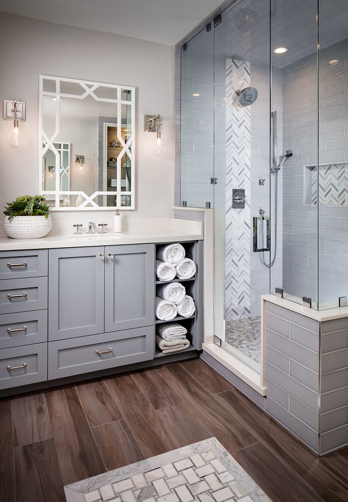 Transitional master bathroom in San Diego with grey cabinets, a freestanding tub, gray tile, subway tile, grey walls, medium hardwood floors, a corner shower, an undermount sink and a hinged shower door.