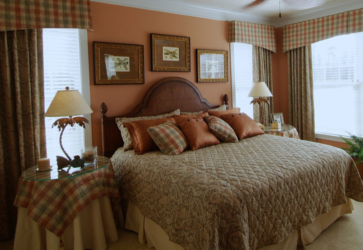 Inspiration for a mid-sized traditional master bedroom in Other with orange walls, carpet and a standard fireplace.