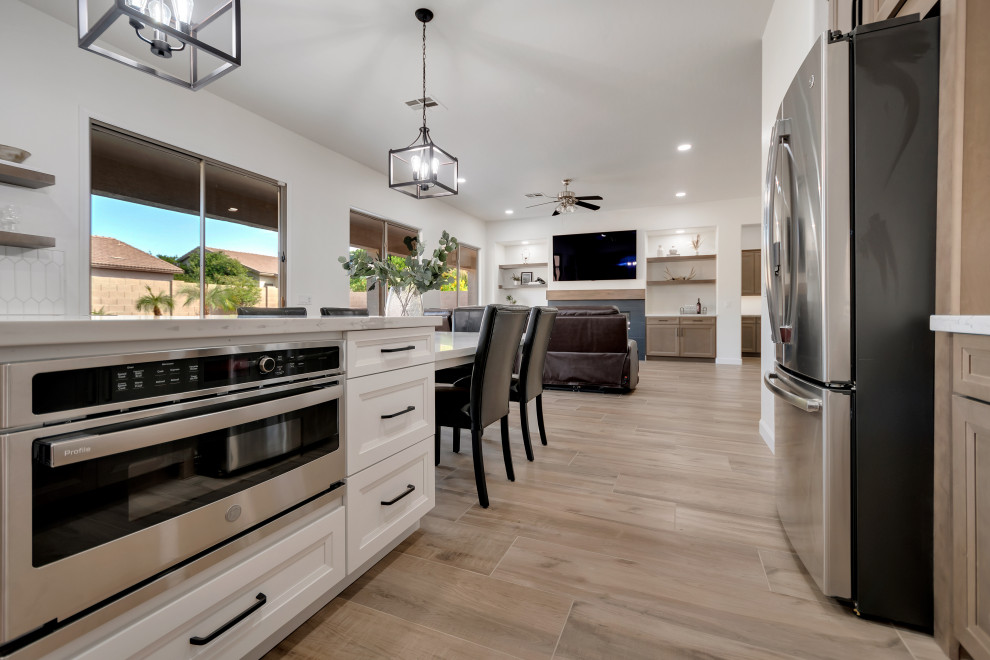 Eat-in kitchen - mid-sized transitional u-shaped ceramic tile and brown floor eat-in kitchen idea in Phoenix with beaded inset cabinets, brown cabinets, quartzite countertops, white backsplash, ceramic backsplash, an island and white countertops