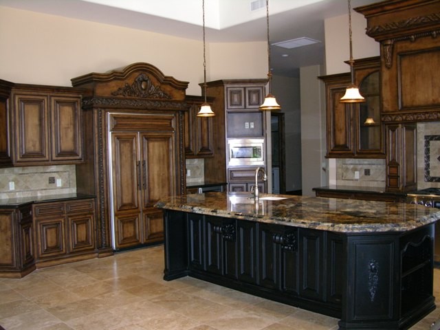 Open concept kitchen - large transitional u-shaped travertine floor open concept kitchen idea in Phoenix with an undermount sink, raised-panel cabinets, dark wood cabinets, granite countertops, multicolored backsplash, ceramic backsplash, paneled appliances and an island