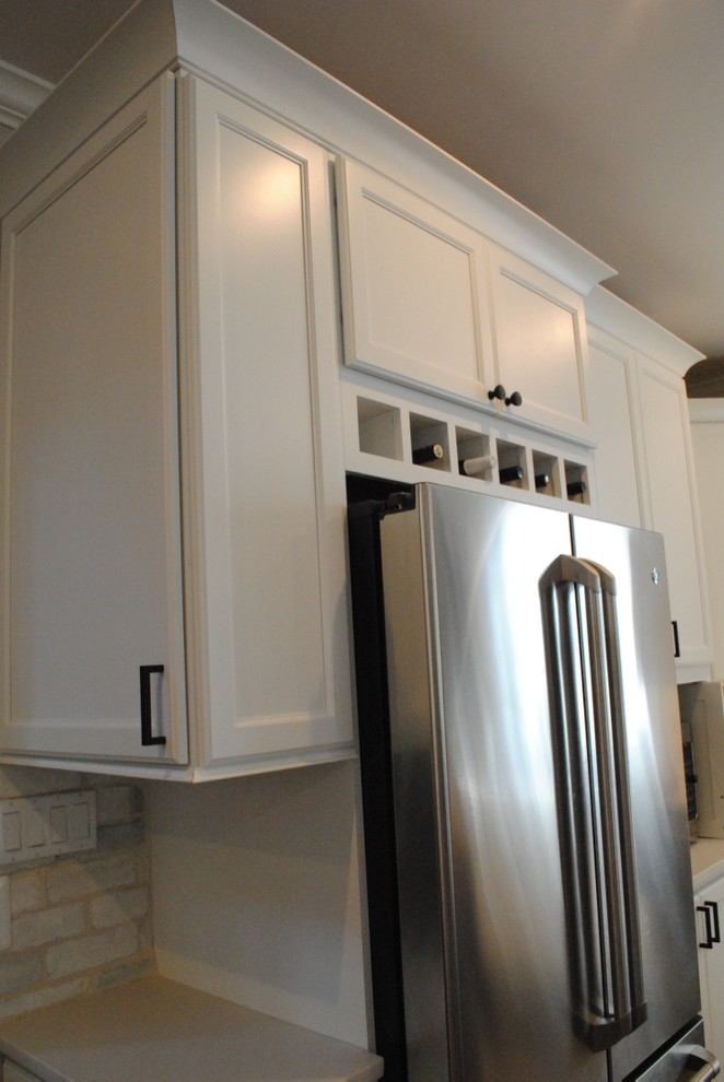 Transitional light wood floor eat-in kitchen photo in Baltimore with a farmhouse sink, flat-panel cabinets, white cabinets, quartz countertops, white backsplash, stone tile backsplash, stainless steel appliances and an island