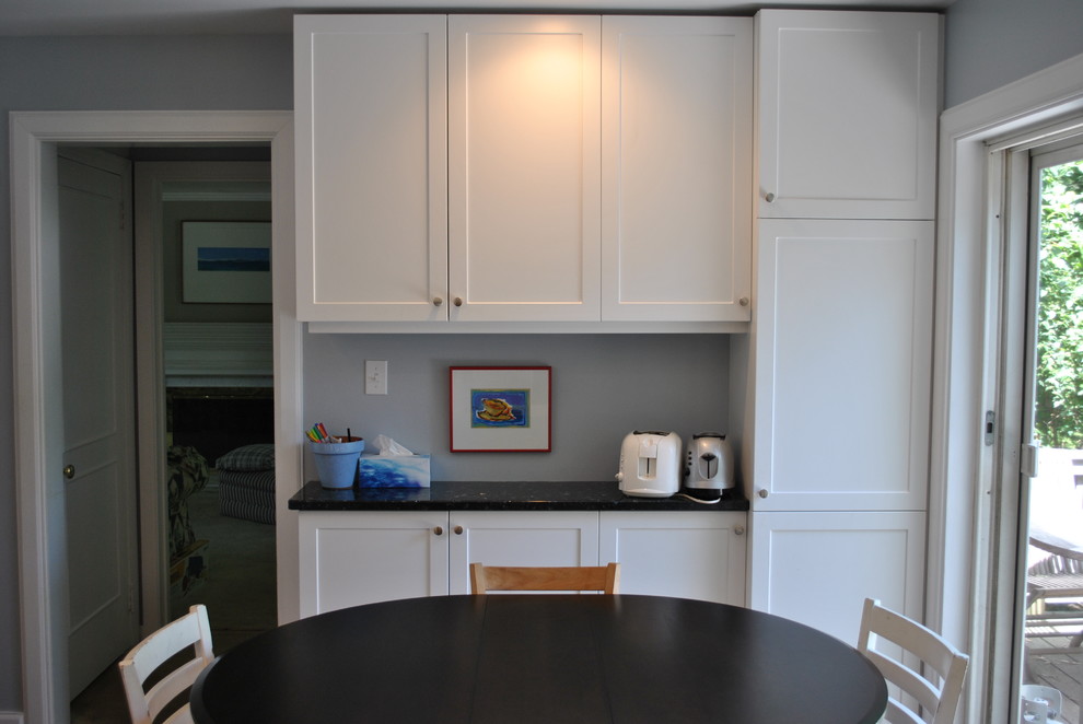 This is an example of a mid-sized transitional galley eat-in kitchen in Other with an undermount sink, shaker cabinets, white cabinets, quartz benchtops, multi-coloured splashback, glass sheet splashback, stainless steel appliances, medium hardwood floors and no island.