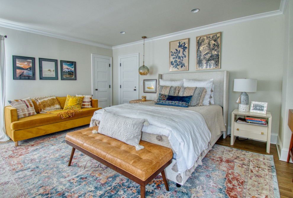 Modelo de habitación de invitados clásica renovada grande con paredes beige, suelo de madera clara y suelo marrón
