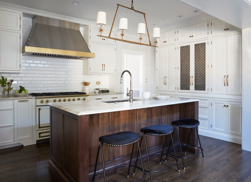 Example of a transitional dark wood floor kitchen design in Chicago with white cabinets, quartzite countertops, white backsplash, porcelain backsplash, colored appliances and an island