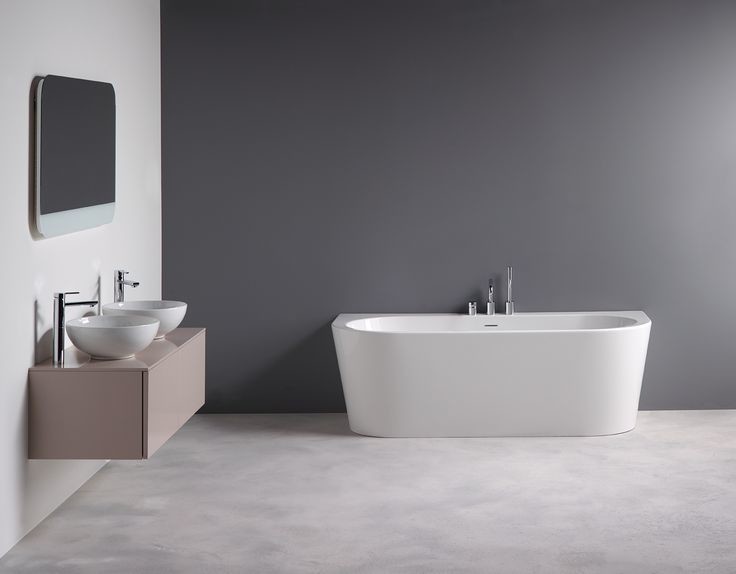 Cette image montre une salle de bain minimaliste de taille moyenne avec une baignoire posée, un mur gris, un sol en marbre et une vasque.