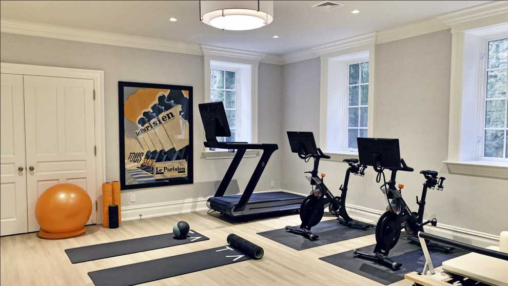 Mid-sized traditional multipurpose gym in New York with grey walls and light hardwood floors.