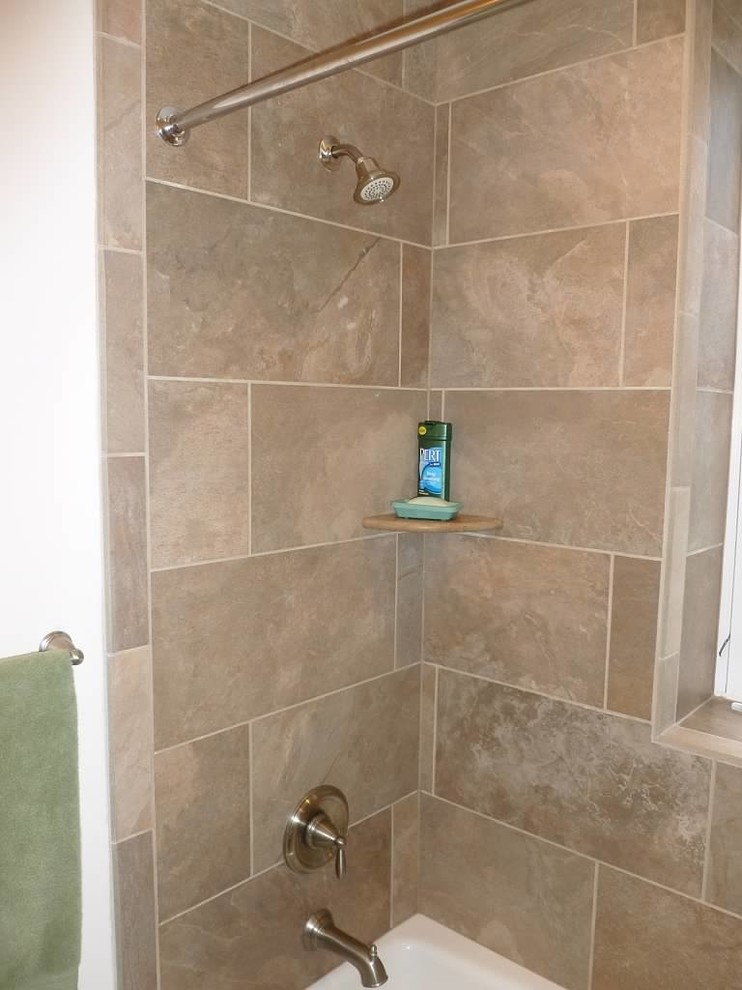 Photo of a small traditional bathroom in Philadelphia with recessed-panel cabinets, white cabinets, an alcove tub, an alcove shower, a two-piece toilet, beige tile, porcelain tile, beige walls, porcelain floors, an integrated sink and solid surface benchtops.