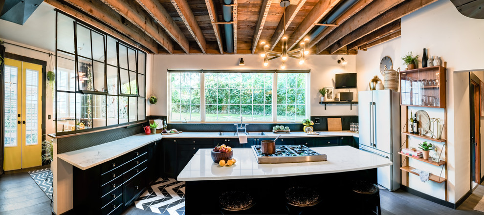 Inspiration for an expansive industrial eat-in kitchen in Providence with an undermount sink, flat-panel cabinets, black cabinets, quartz benchtops, black splashback, ceramic splashback, stainless steel appliances, ceramic floors, with island, multi-coloured floor and white benchtop.