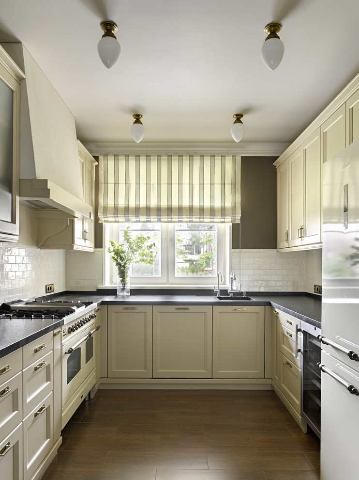 Large contemporary u-shaped separate kitchen in Moscow with a single-bowl sink, recessed-panel cabinets, white appliances, medium hardwood floors, no island, window splashback, beige cabinets and white splashback.