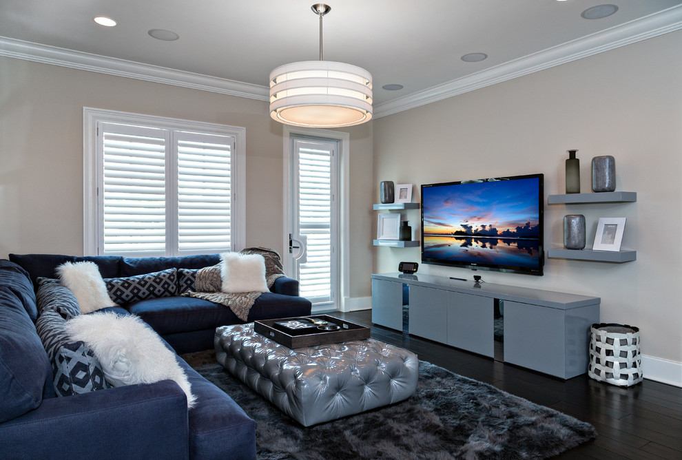 This is an example of a mid-sized transitional open concept family room in Miami with beige walls, a wall-mounted tv, dark hardwood floors and no fireplace.