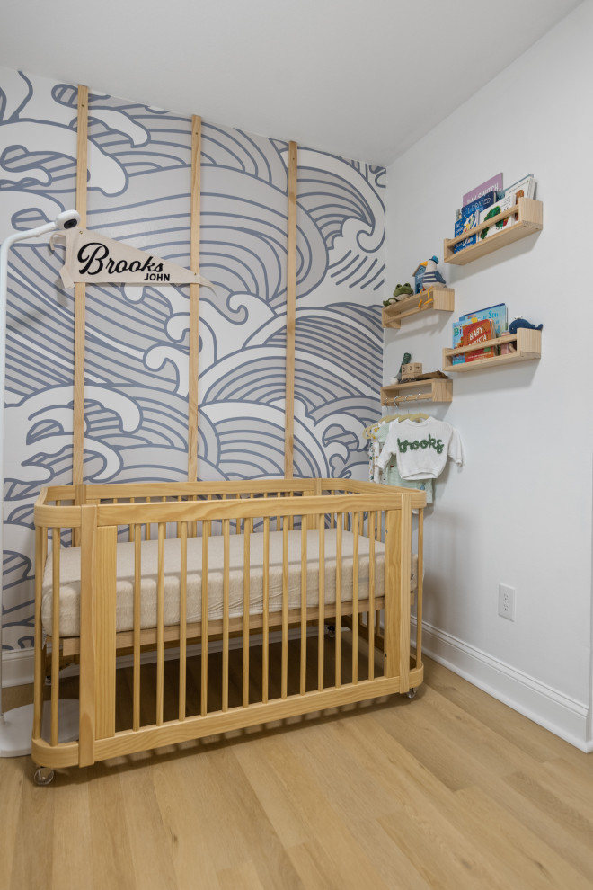 Diseño de habitación de bebé neutra marinera de tamaño medio con paredes blancas, suelo vinílico, suelo beige y bandeja