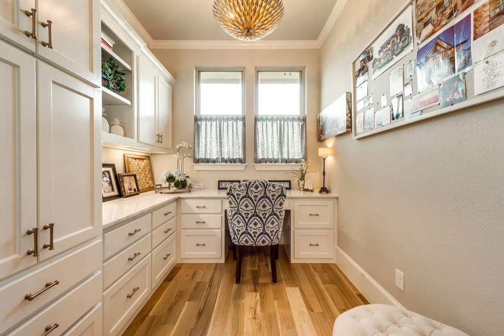 Mid-sized transitional study room in Dallas with beige walls, light hardwood floors and a built-in desk.