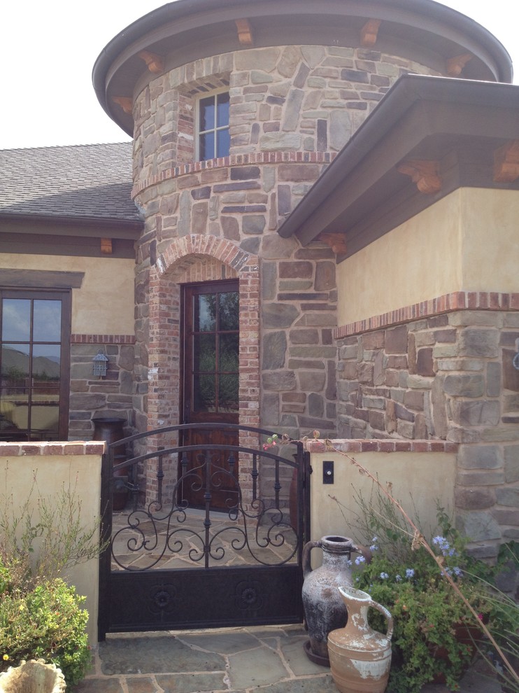 Photo of a mediterranean beige exterior in Austin with mixed siding.