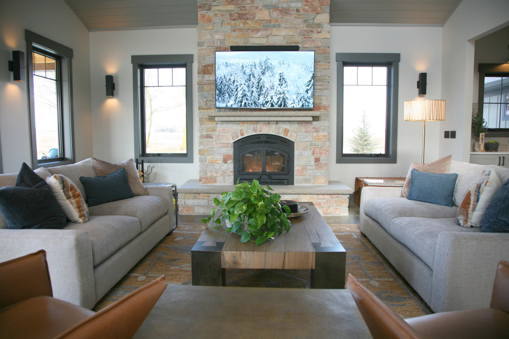Inspiration for a large rustic open plan living room in Milwaukee with concrete flooring, a wood burning stove, a stone fireplace surround, a wall mounted tv, grey floors, a wood ceiling and tongue and groove walls.