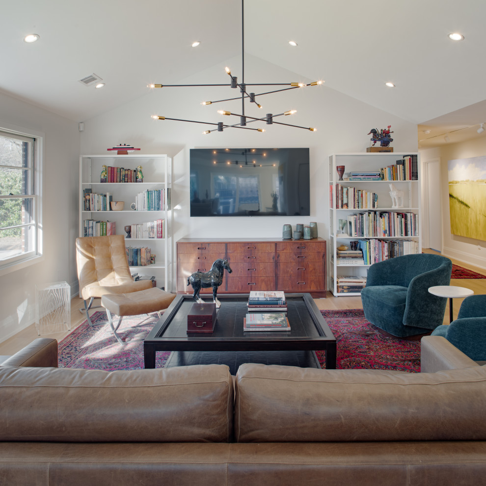 Immagine di un soggiorno design di medie dimensioni e aperto con pareti bianche, parquet chiaro, TV a parete e soffitto a volta