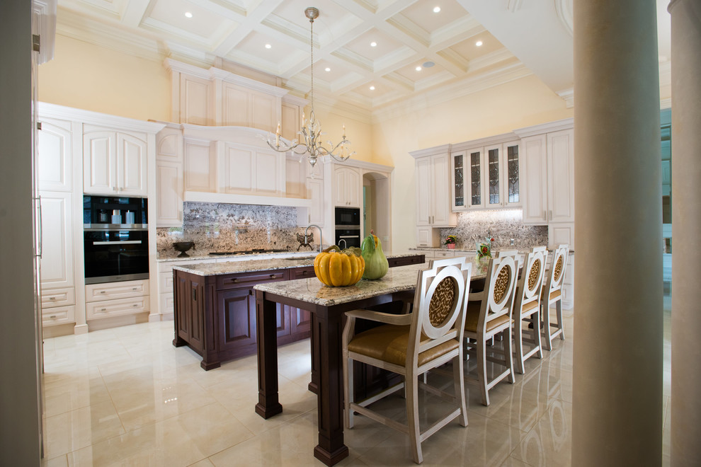 Kitchen - traditional kitchen idea with an undermount sink, raised-panel cabinets, white cabinets, granite countertops and two islands