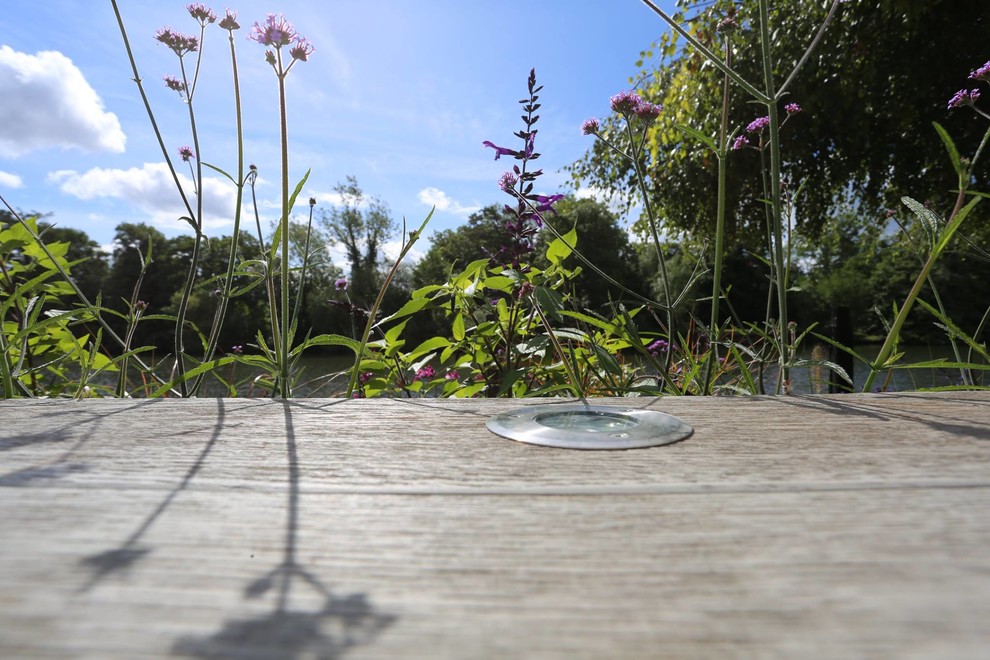 Small beach style back patio in London with a fire feature and decking.