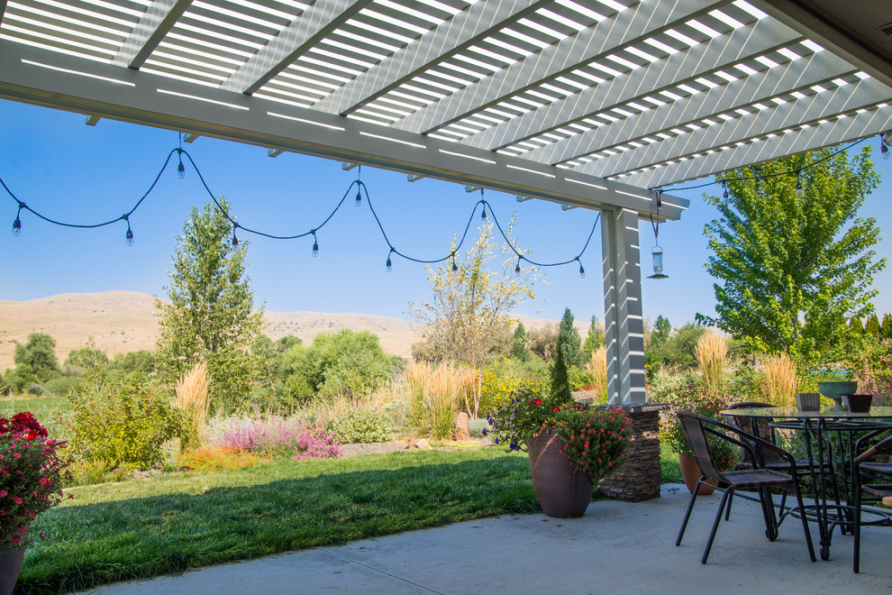 Mid-sized modern backyard patio in Boise with a pergola.