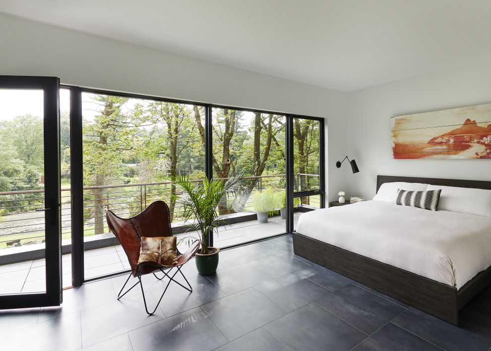 На фото: хозяйская спальня среднего размера в стиле модернизм с белыми стенами, полом из сланца и серым полом