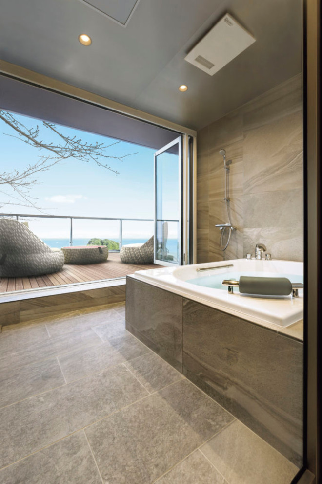 Idée de décoration pour une salle de bain minimaliste avec une baignoire posée, un carrelage beige, un mur beige, un sol beige et un plafond décaissé.