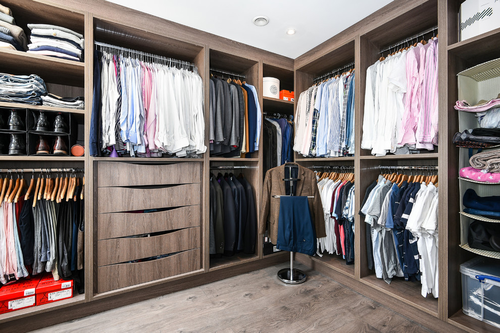 Photo of a large contemporary men's walk-in wardrobe in Buckinghamshire with medium wood cabinets, brown floor, open cabinets and dark hardwood floors.