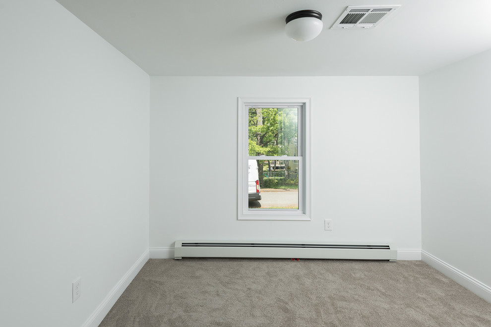 Photo of a small transitional guest bedroom in Boston with white walls, carpet, no fireplace and beige floor.