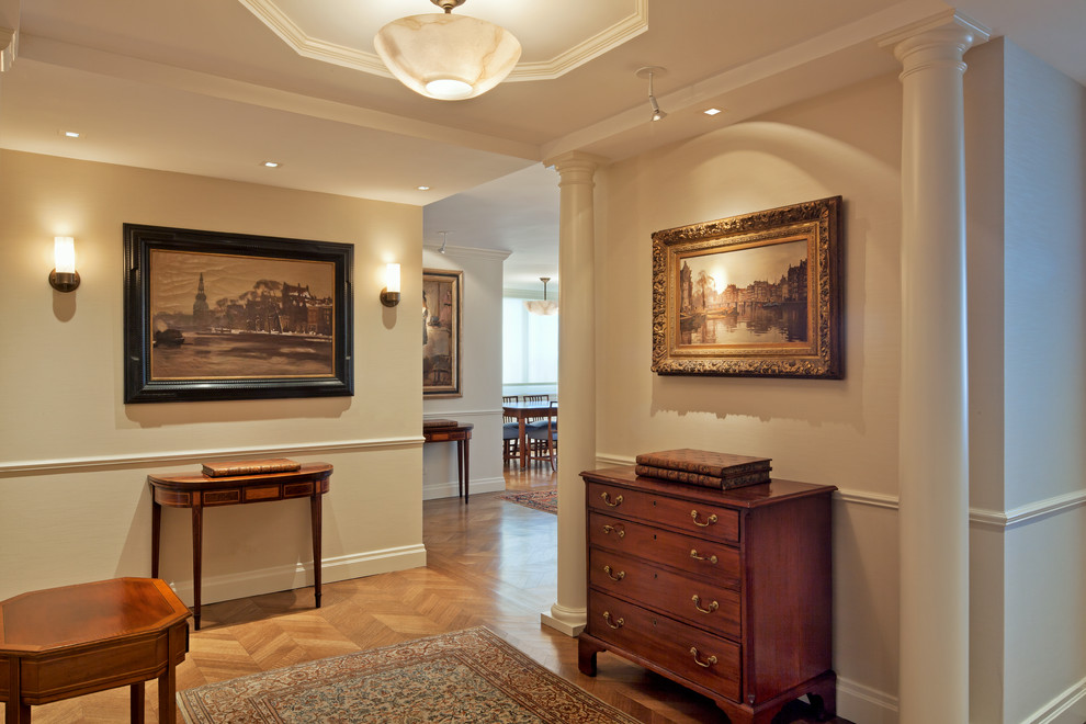 Photo of a mid-sized traditional hallway in New York with beige walls and light hardwood floors.