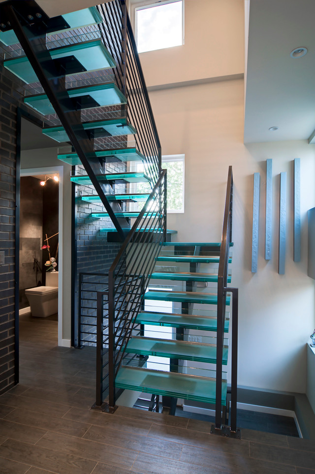 Mid-sized contemporary glass u-shaped staircase in Denver with open risers and metal railing.