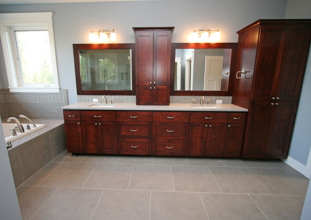 Design ideas for a large transitional master bathroom in Seattle with an undermount sink, recessed-panel cabinets, dark wood cabinets, engineered quartz benchtops, a drop-in tub, an alcove shower, a two-piece toilet, gray tile, porcelain tile, grey walls and porcelain floors.