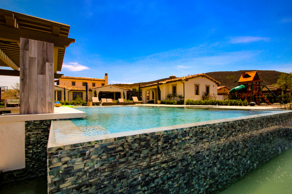 Großer, Gefliester Moderner Infinity-Pool hinter dem Haus in rechteckiger Form mit Pool-Gartenbau in San Diego